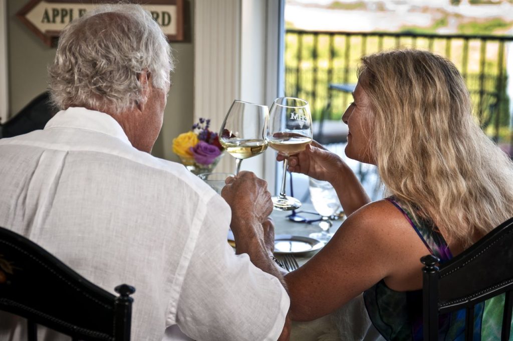 Older Couple toast their getaway with white wine